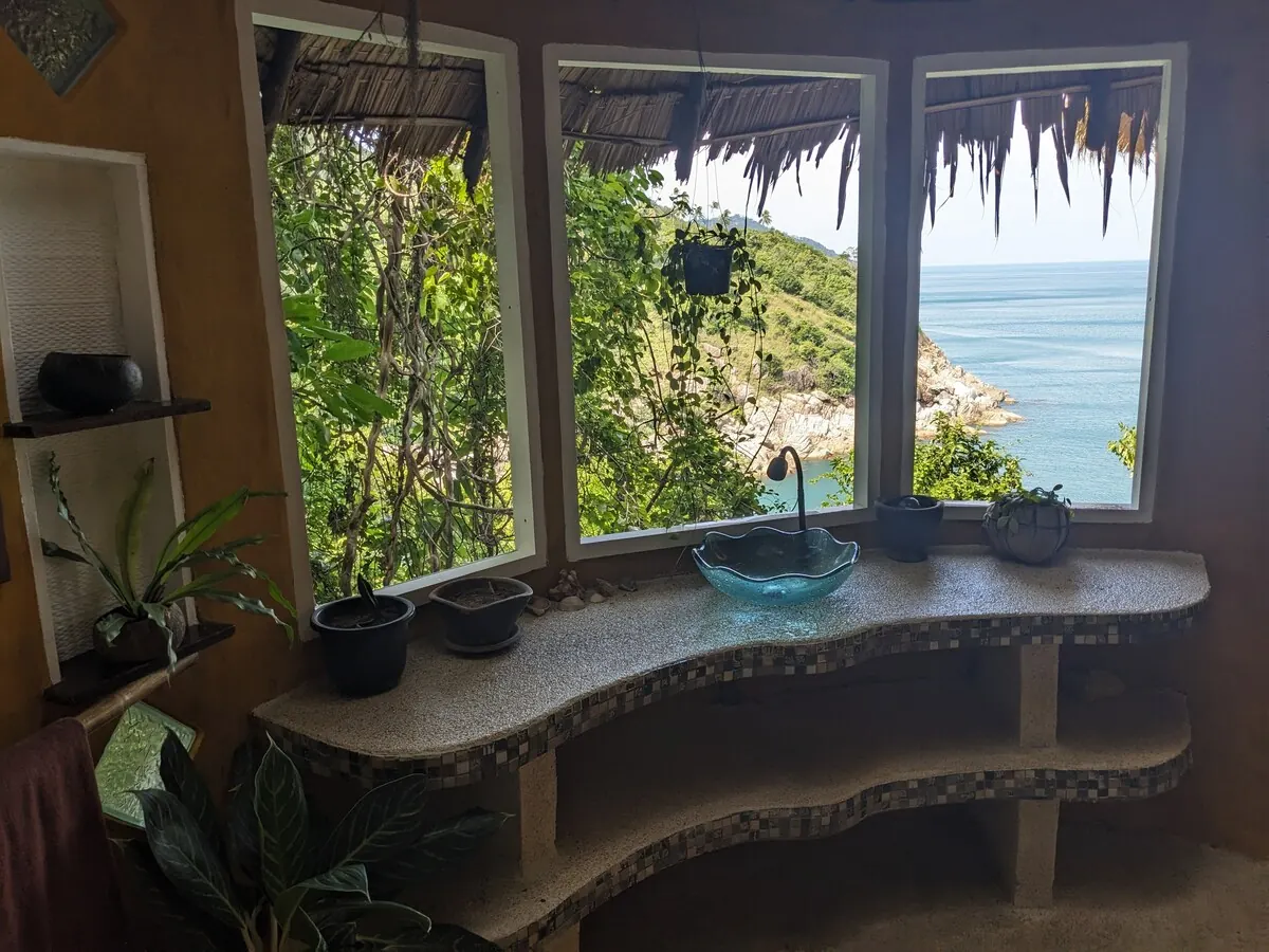 Curved stone washbasin counter with a window onto the sea