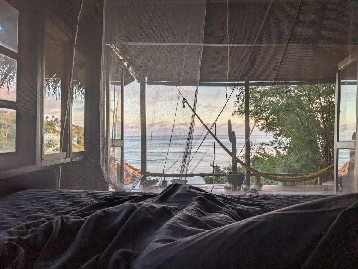 Waking up in the king bed with the ocean and jungle through the open windows