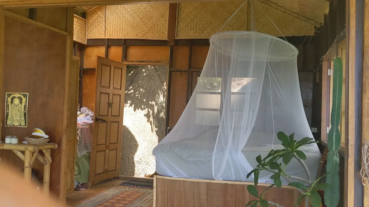 King bed under a white mosquito net in the handmade wooden bedroom