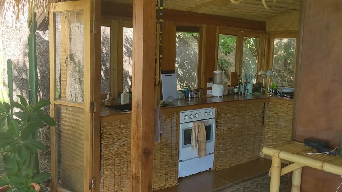 Fully equipped wooden kitchen with oven, cooker and fridge