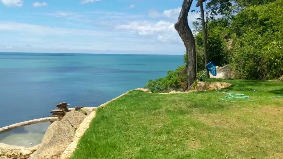 Lawn and rock pool with open ocean horizon