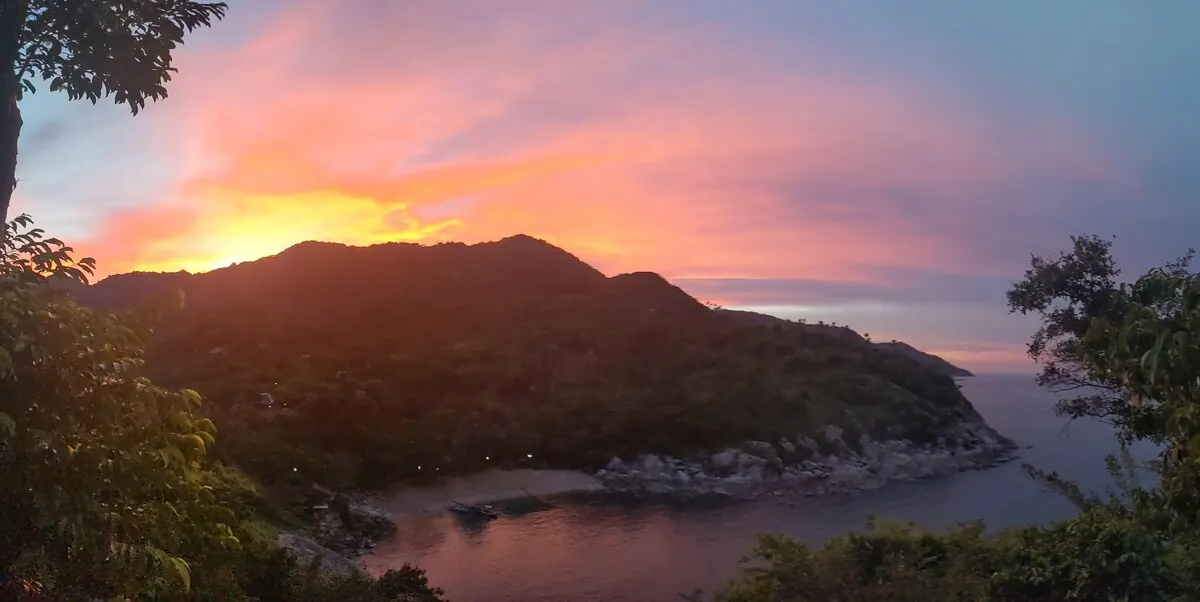 Orange and pink sunset behind the mountains above Why Nam bay